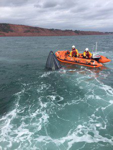 Inshore lifeboat, George Bearman crew volunteers stay on scene to watch over the sinking motorboat. Photo Credit: Exmouth RNLI