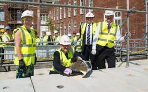  (front from left to right) Mairead McAlinden, CEO South Devon Healthcare NHS Foundation Trust; Sir Richard Ibbotson, Chairman South Devon Healthcare NHS Foundation Trust, fixing the last block in place; Simon Parsons, Kier and Dr David Sinclair, Deputy Medical Director South Devon Healthcare NHS Foundation Trust. (Back) Patients, community partners, and past and present hospital staff.