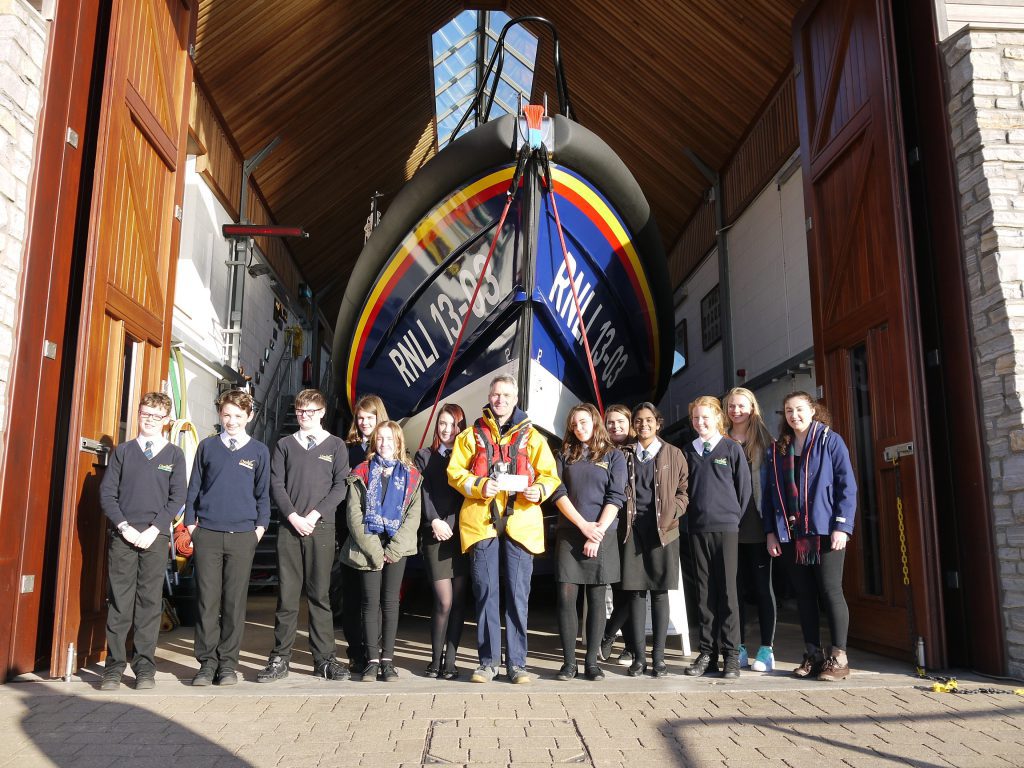 Clyst Vale students handing over the cheque to Coxswain, Steve Hockings-Thompson in front of Shannon class lifeboat R and J Welburn